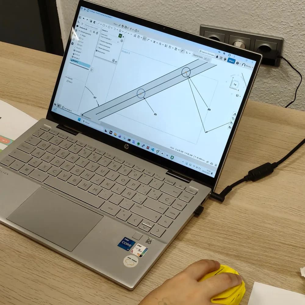 Portátil con el diseño en CAD de una pieza del proyecto en pantalla