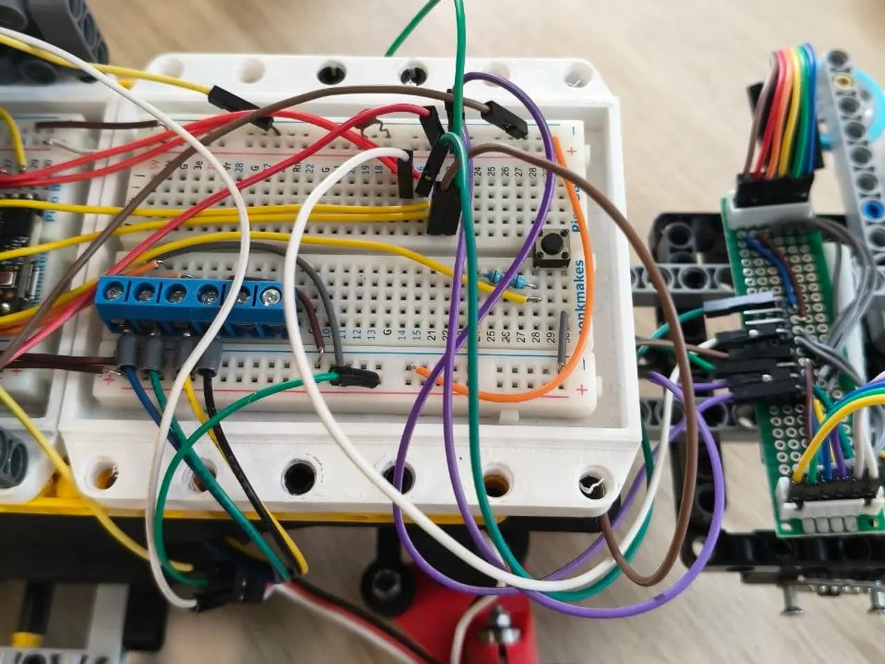 Protoboard con el circuito cableado montada sobre el chasis de un robot