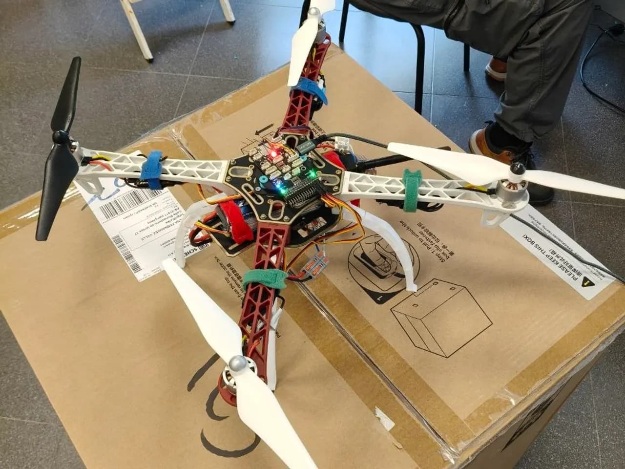 Dron cuadricóptero a medio montar sobre la mesa, con la electrónica todavía a la vista