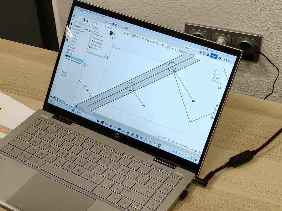 Portátil con el diseño en CAD de una pieza del proyecto en pantalla