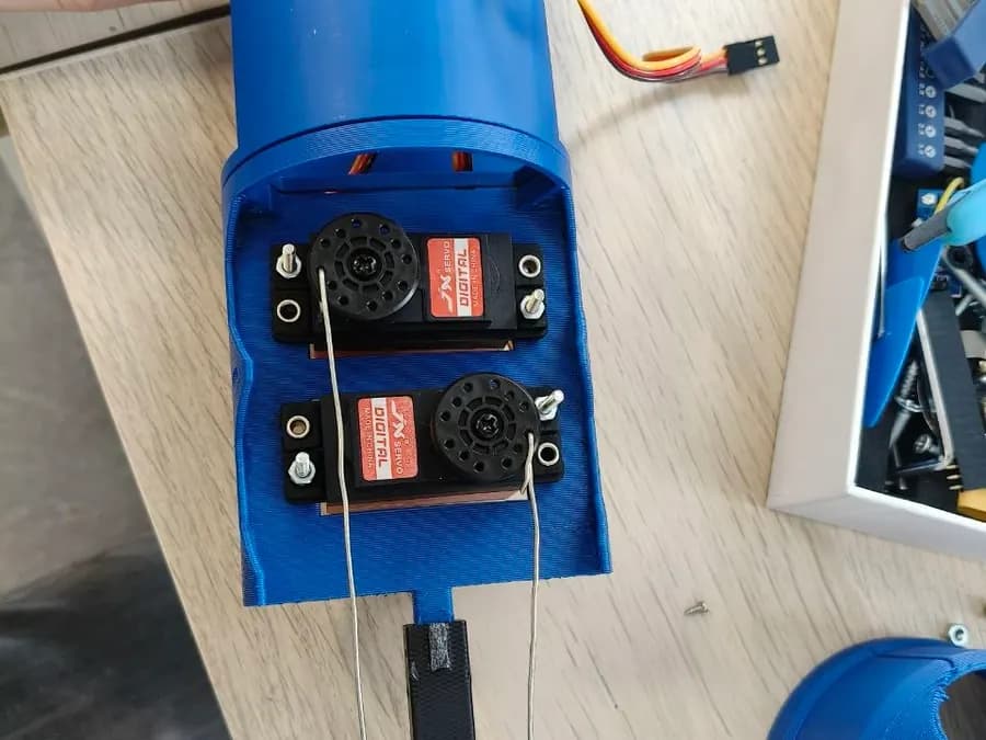 Pieza impresa en 3D con dos servos montados, del proyecto del Club